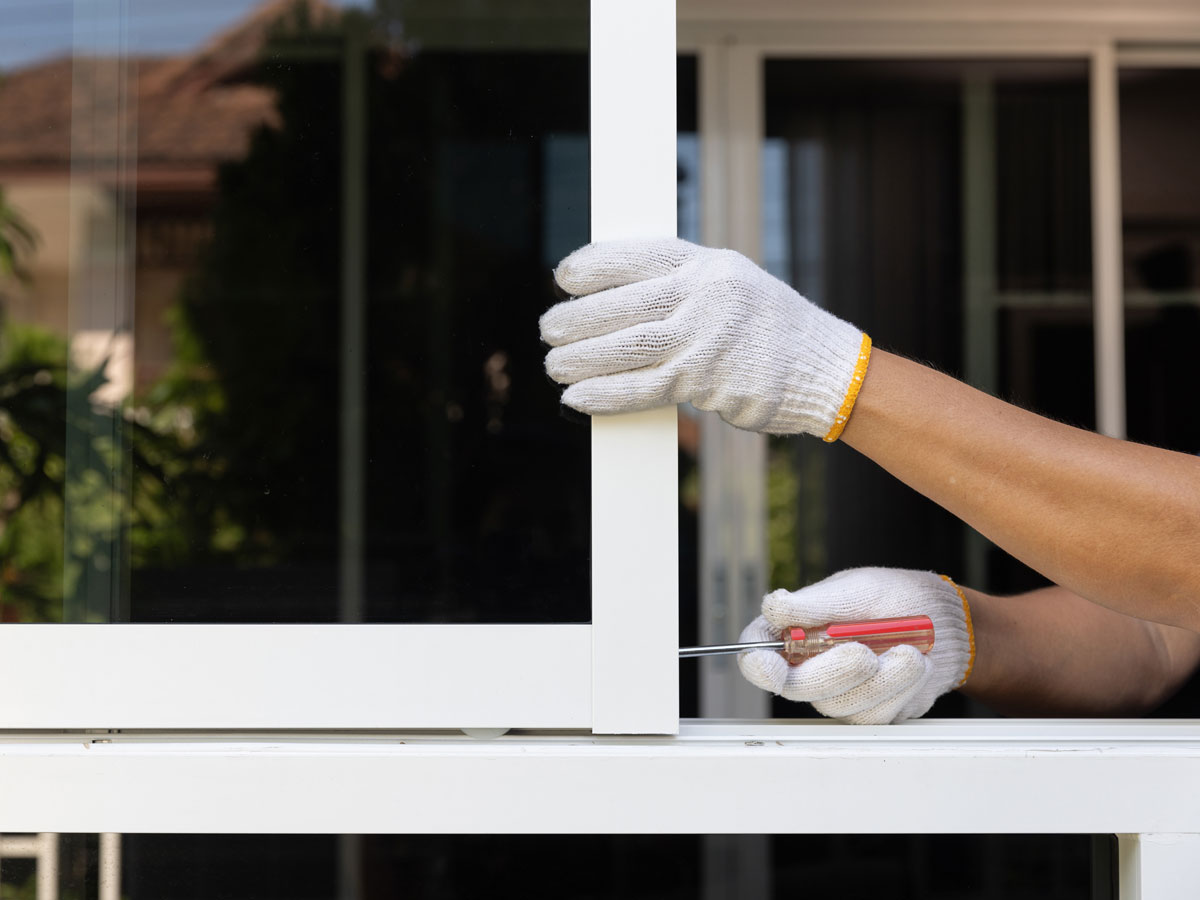 Worker installing aluminium sliding window in an apartment